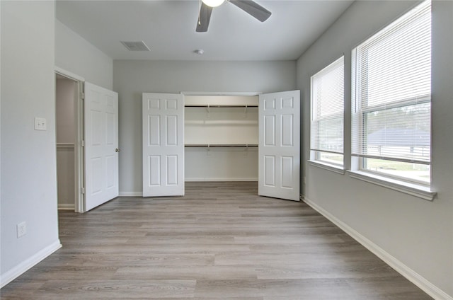 unfurnished bedroom featuring light hardwood / wood-style floors, a closet, and ceiling fan