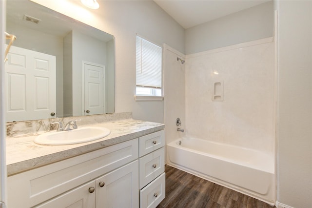 bathroom with tub / shower combination, hardwood / wood-style floors, and vanity