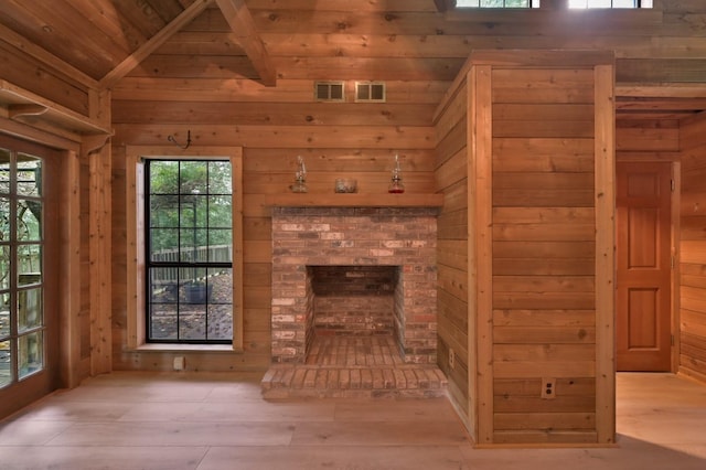 unfurnished living room with high vaulted ceiling, a fireplace, wood ceiling, and wood walls