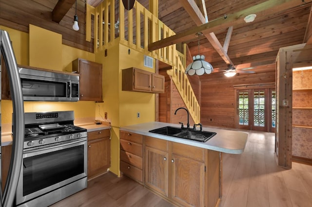 kitchen with wood ceiling, appliances with stainless steel finishes, a peninsula, light countertops, and a sink