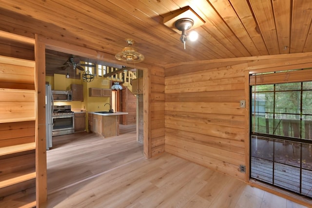 interior space featuring sink, wooden walls, wooden ceiling, and light hardwood / wood-style floors