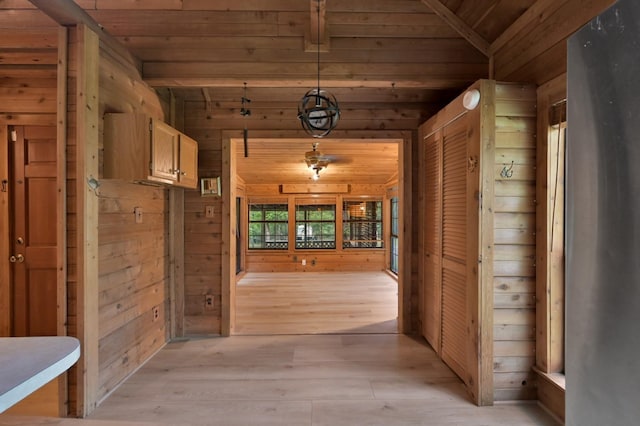 hallway with wood ceiling, lofted ceiling, and wood walls