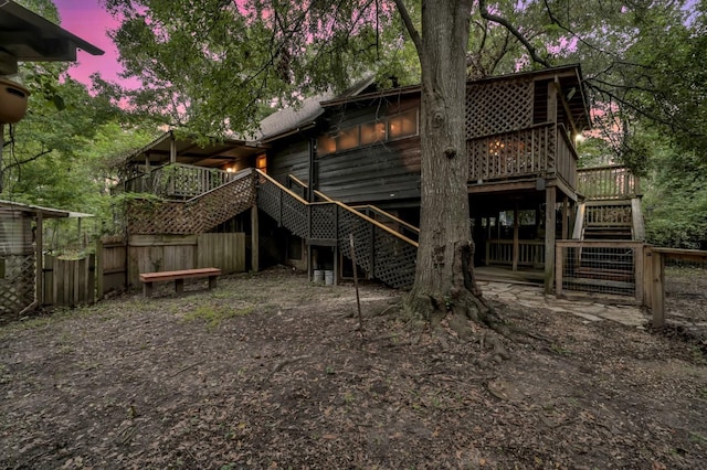 back house at dusk featuring a wooden deck