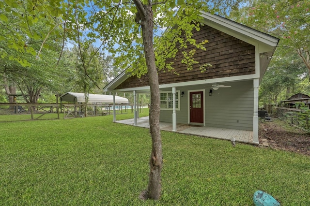 back of property with a ceiling fan, fence, a patio, and a lawn