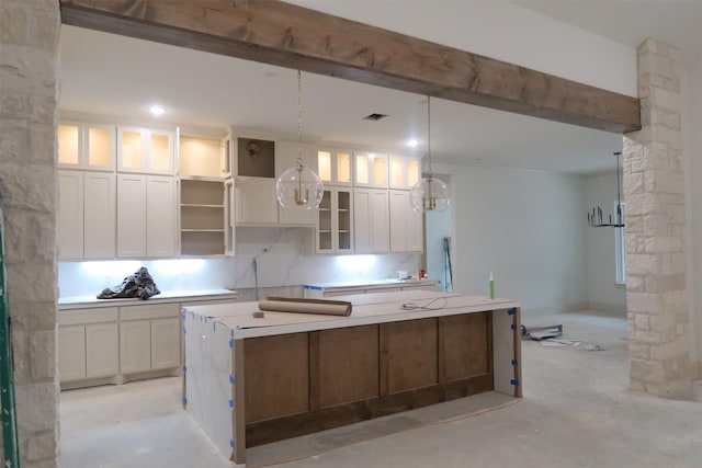 kitchen featuring glass insert cabinets, white cabinets, light countertops, and a kitchen island