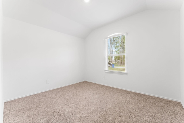 empty room featuring carpet flooring and vaulted ceiling