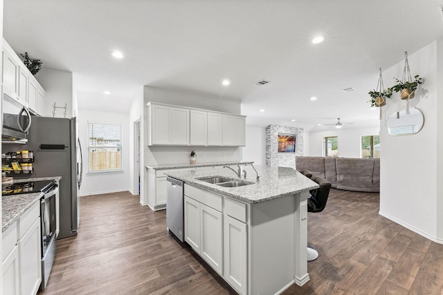 kitchen featuring light stone counters, sink, white cabinetry, and stainless steel appliances