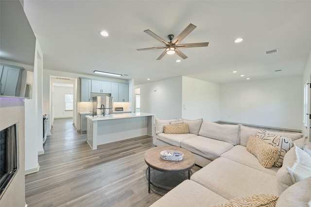 living room featuring light hardwood / wood-style flooring and ceiling fan