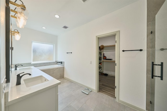 bathroom with tile patterned floors, vanity, and separate shower and tub