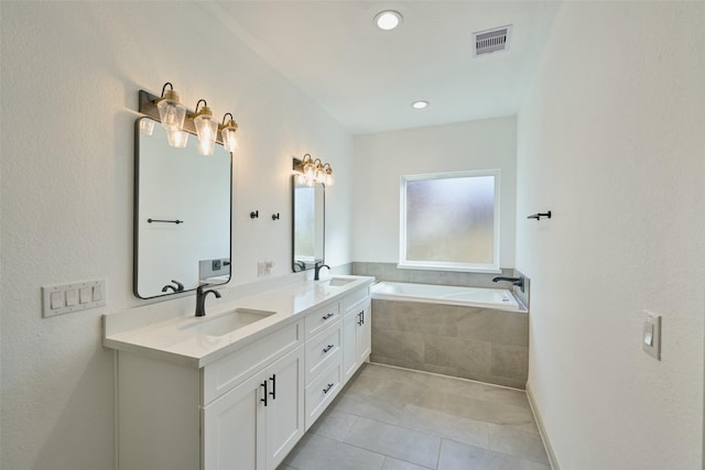 bathroom featuring vanity, tile patterned floors, and a relaxing tiled tub