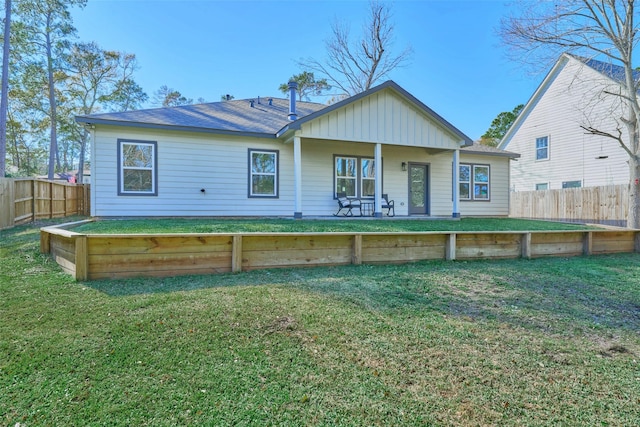 rear view of house featuring a lawn