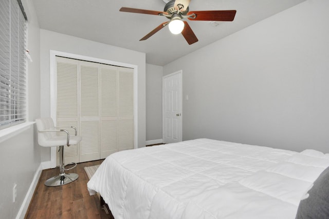 bedroom with dark wood-type flooring, ceiling fan, and a closet