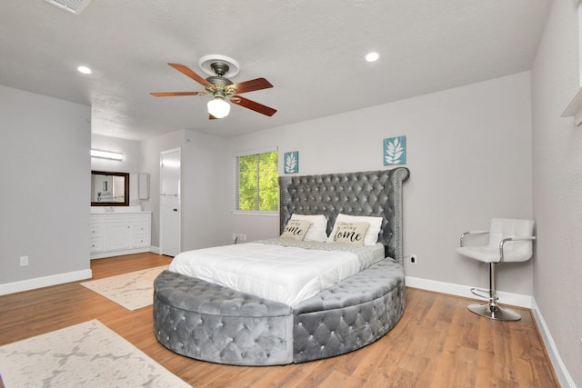 bedroom featuring hardwood / wood-style flooring and ensuite bath