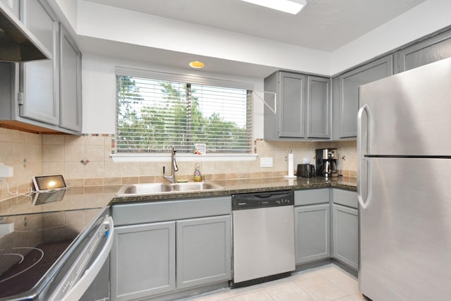 kitchen featuring gray cabinets, extractor fan, sink, decorative backsplash, and stainless steel appliances