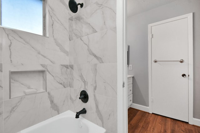 bathroom featuring tiled shower / bath, wood-type flooring, and vanity