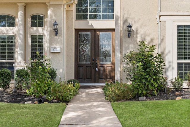 entrance to property featuring a lawn