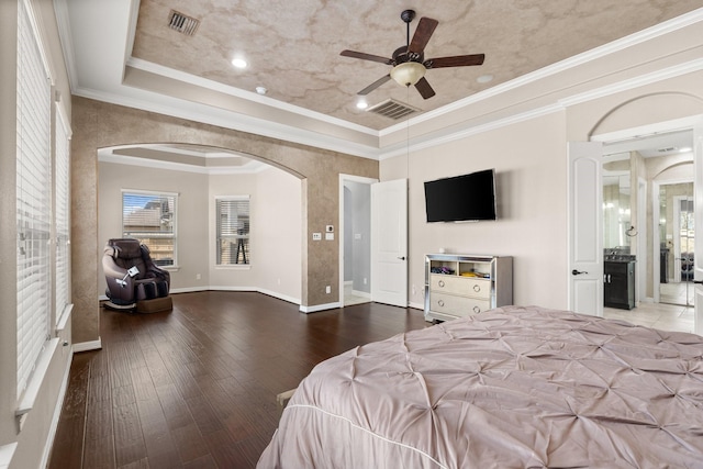 bedroom featuring ornamental molding, ceiling fan, a raised ceiling, and hardwood / wood-style floors