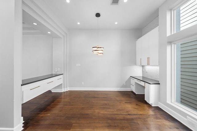 interior space with dark wood-type flooring and built in desk