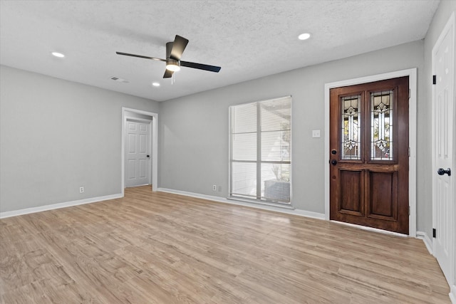 foyer featuring light hardwood / wood-style floors, a textured ceiling, and ceiling fan