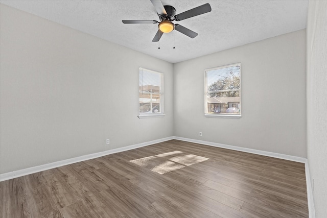 empty room featuring a textured ceiling, ceiling fan, and dark hardwood / wood-style flooring