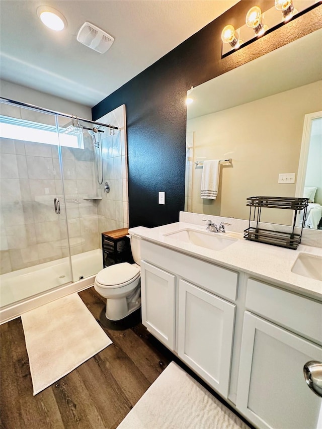 bathroom featuring a shower with shower door, hardwood / wood-style floors, and vanity