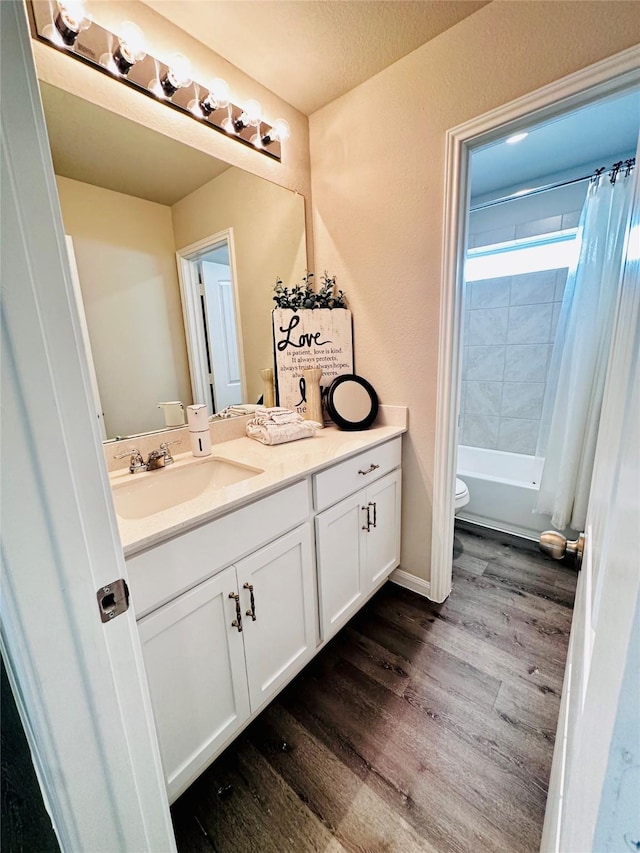 full bathroom with toilet, shower / bath combo with shower curtain, a textured ceiling, wood-type flooring, and vanity