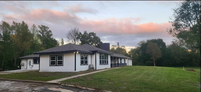 property exterior at dusk featuring a yard