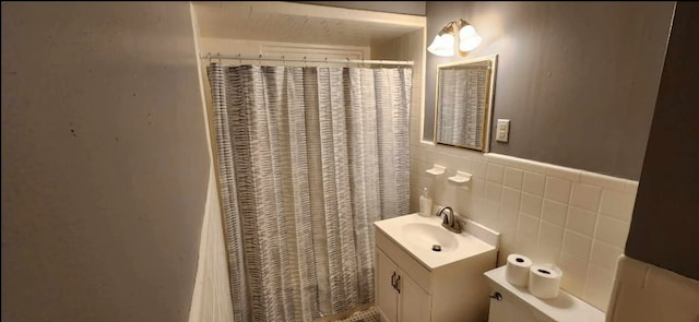 bathroom featuring curtained shower, tile walls, and vanity