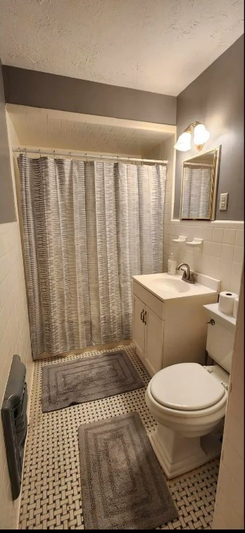 bathroom with toilet, tile walls, tile patterned flooring, a shower with shower curtain, and vanity