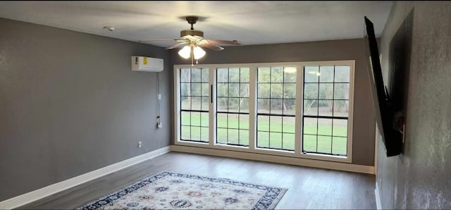 empty room with ceiling fan, hardwood / wood-style floors, and a wall unit AC