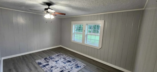 spare room featuring crown molding, a textured ceiling, dark hardwood / wood-style floors, and ceiling fan