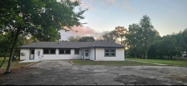 single story home featuring central AC unit and a lawn