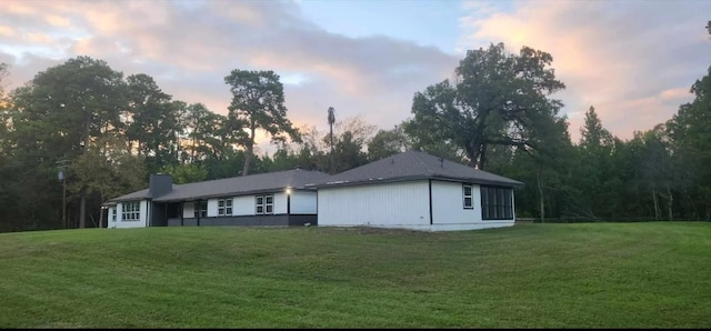 property exterior at dusk with a yard