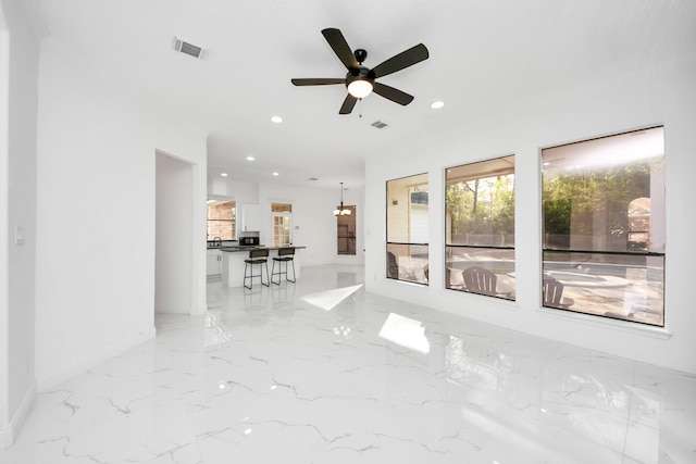 unfurnished living room with ceiling fan