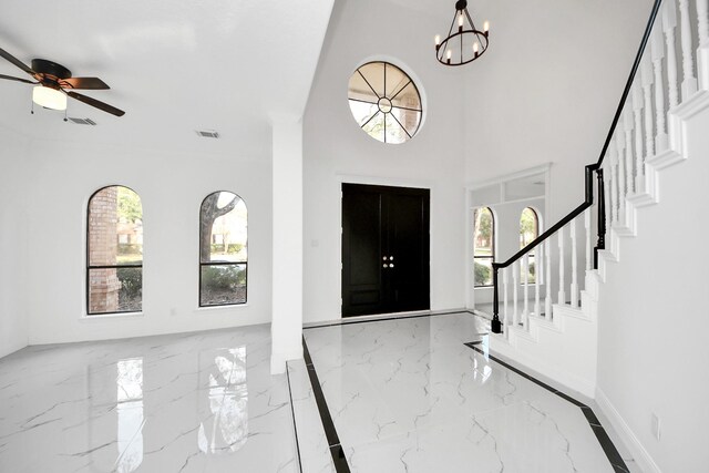 entryway with ceiling fan with notable chandelier