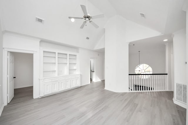 unfurnished living room featuring ceiling fan with notable chandelier, light hardwood / wood-style floors, and high vaulted ceiling