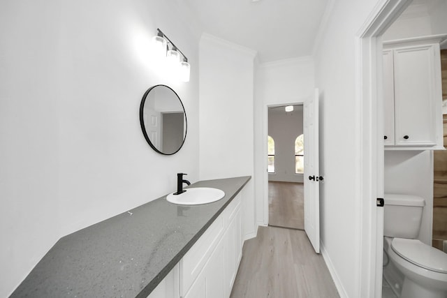 bathroom with crown molding, vanity, toilet, and hardwood / wood-style floors