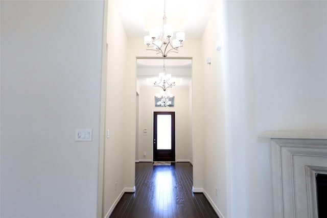 doorway to outside with dark hardwood / wood-style floors and a notable chandelier