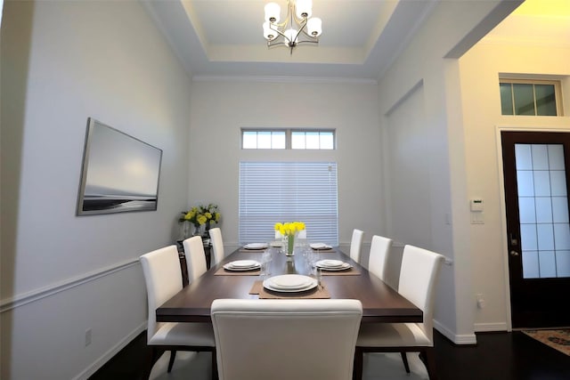 dining space featuring a notable chandelier and a raised ceiling