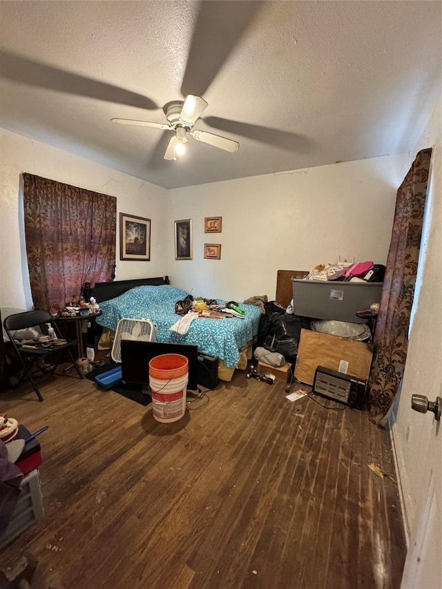 unfurnished bedroom with ceiling fan, wood-type flooring, and a textured ceiling