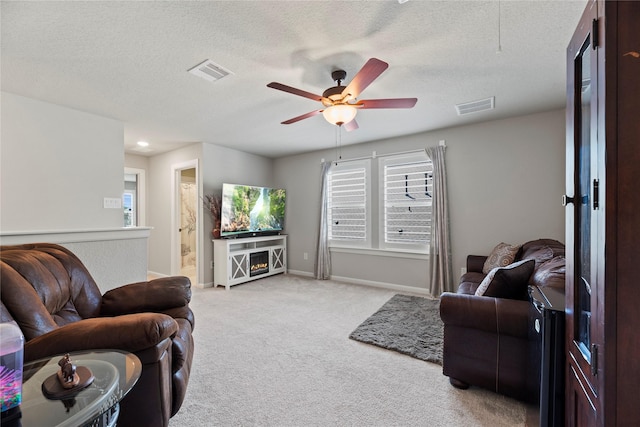 living room featuring light carpet, a textured ceiling, and ceiling fan