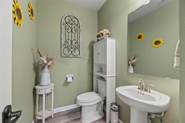 bathroom with sink, hardwood / wood-style flooring, and toilet