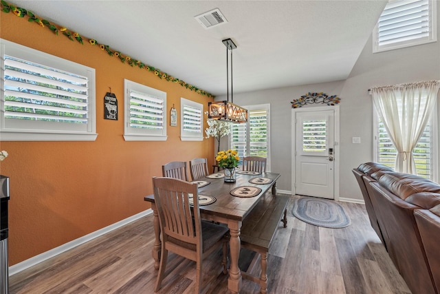 dining room with hardwood / wood-style flooring and a chandelier