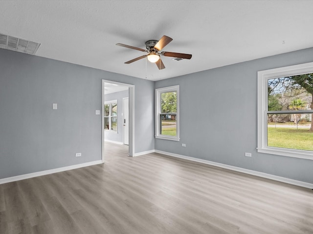 spare room with ceiling fan, light hardwood / wood-style flooring, and a textured ceiling