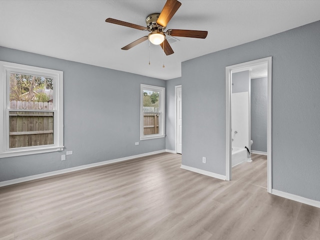 unfurnished bedroom featuring ceiling fan, connected bathroom, and light hardwood / wood-style flooring