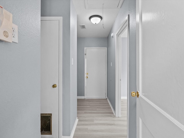 corridor with light hardwood / wood-style floors