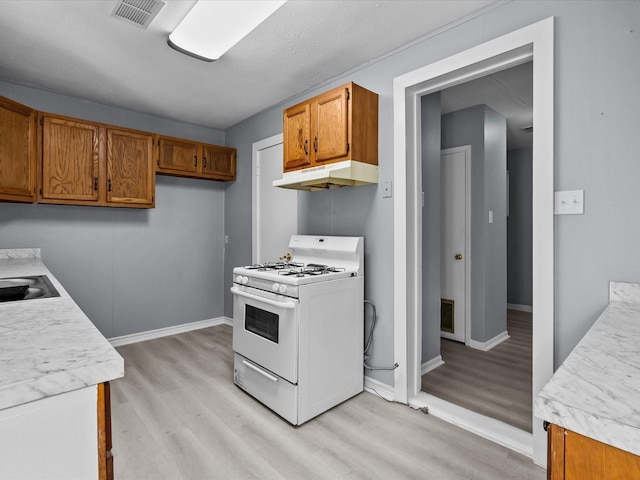 kitchen with light hardwood / wood-style flooring and white gas range oven