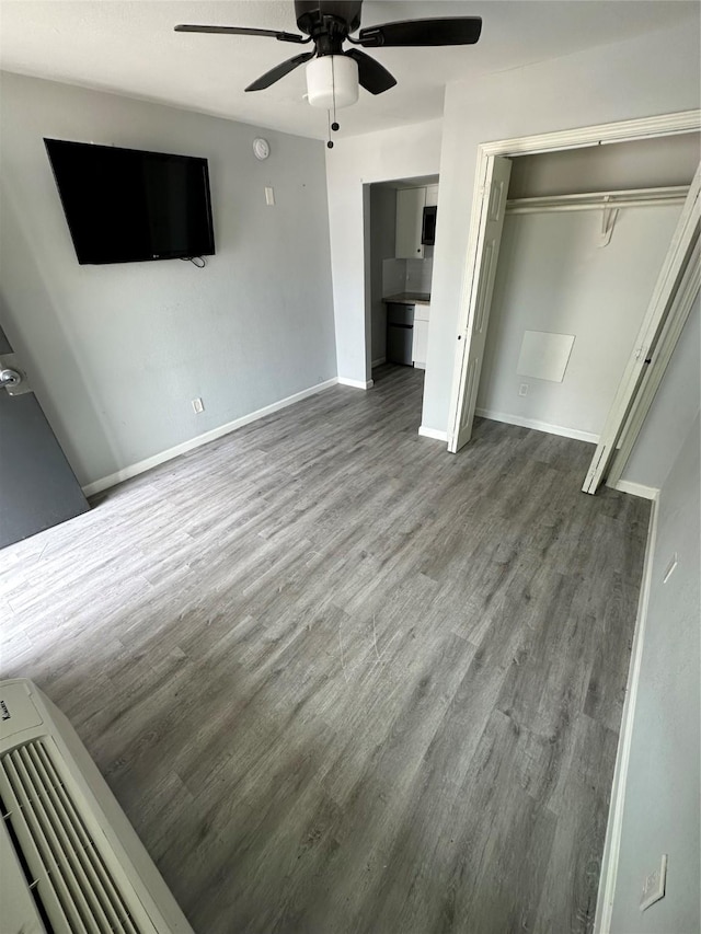 unfurnished bedroom with wood-type flooring, a closet, and ceiling fan