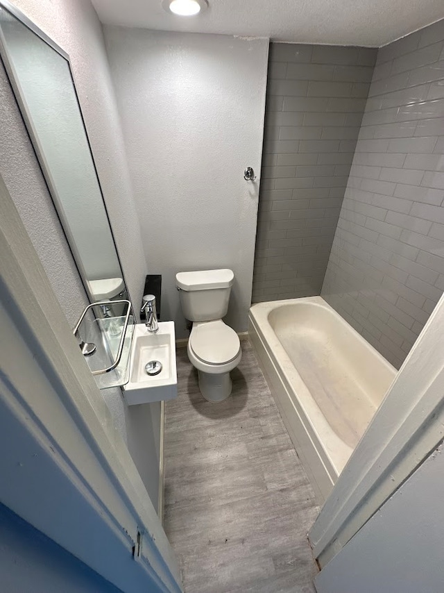 bathroom with hardwood / wood-style flooring and toilet