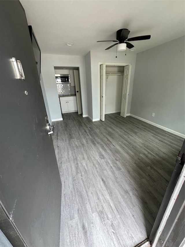 unfurnished living room with ceiling fan and hardwood / wood-style floors